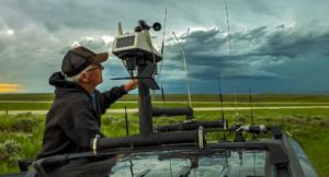Man standing next to storm chasing vehicle.