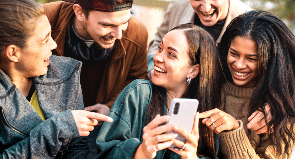 5 friends gathering around a smartphone