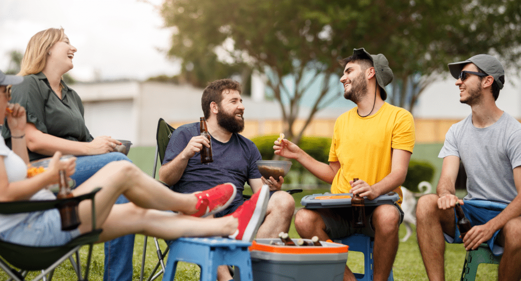 A group of five tailgaters sitting and having a few beers