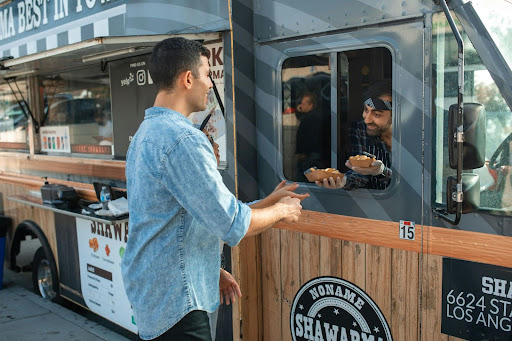 man purchasing food from a food truck