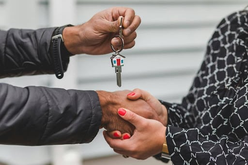 people shaking hands and passing off a key