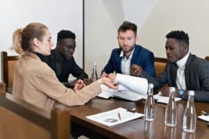 group of people sitting at table with documents